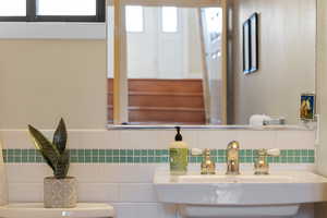 Half bathroom with decorative backsplash and tile walls