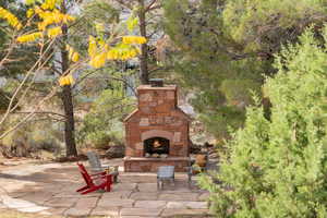 View of patio with an outdoor stone fireplace