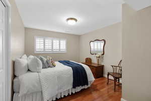Bedroom with wood finished floors and multiple windows