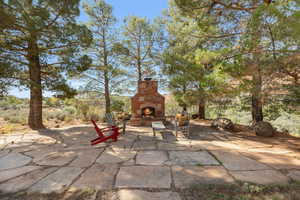 View of patio with an outdoor stone fireplace