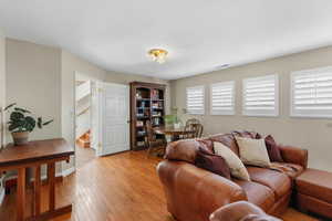 Living area with hardwood / wood-style flooring and stairs
