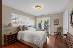 Bedroom with wood finished floors, access to outside, and a closet