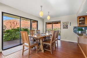 Dining space with dark wood-type flooring and baseboards