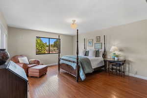 Bedroom with hardwood / wood-style flooring and baseboards