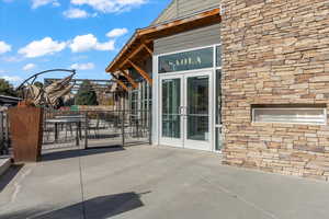 View of exterior entry with stone siding, french doors, and a patio area
