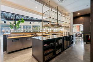 Bar featuring dark cabinetry, recessed lighting, and dark countertops