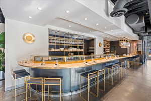 Indoor wet bar featuring recessed lighting and light countertops