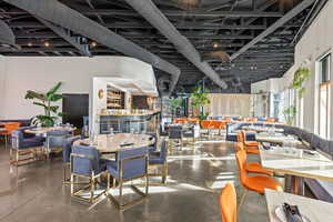 Dining space with concrete floors and a high ceiling