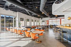 Dining room with concrete flooring and a towering ceiling