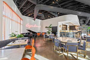 Dining area with concrete floors, plenty of natural light, and a high ceiling