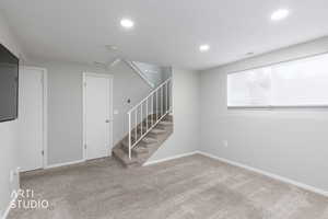 Basement with carpet floors, stairs, and recessed lighting