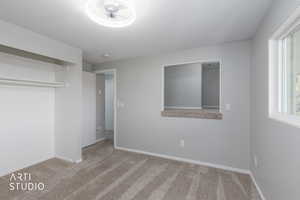 Unfurnished bedroom with light carpet and a closet