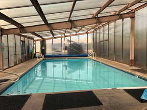 Indoor pool featuring a sunroom