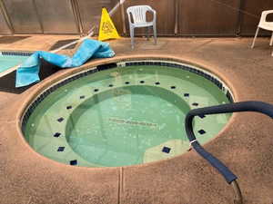 View of swimming pool with an in-ground hot tub and a swimming pool