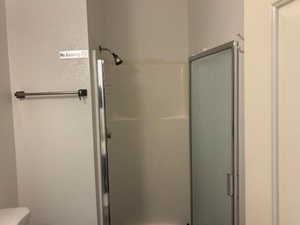 Bathroom featuring a shower stall and toilet