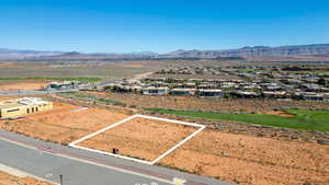 Aerial view of residential area with property parcel outlined and mountains