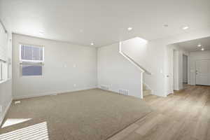 Unfurnished room featuring stairs, recessed lighting, and light wood-type flooring