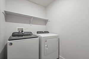 Washroom featuring washing machine and clothes dryer and baseboards