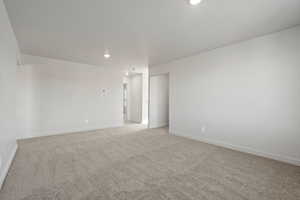 Unfurnished room featuring light carpet, recessed lighting, and a textured ceiling