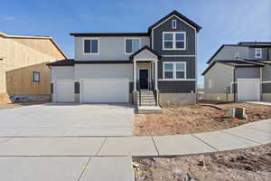 View of front facade featuring driveway, board and batten siding, and a garage
