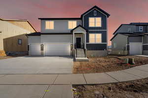 View of front facade featuring board and batten siding, concrete driveway, and an attached garage