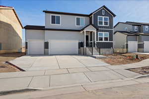 View of front of house with an attached garage, driveway, and board and batten siding
