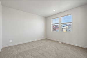Spare room with light colored carpet and baseboards