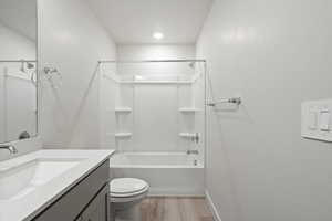 Bathroom featuring vanity, shower / washtub combination, and light wood finished floors