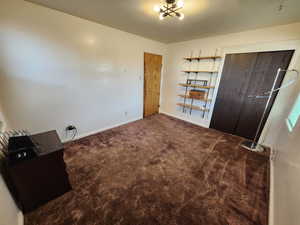 Unfurnished bedroom with dark colored carpet and a closet