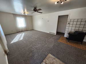 Carpeted spare room with ceiling fan and baseboards