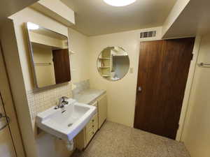 Bathroom featuring backsplash and a sink