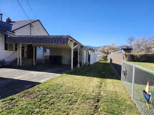 View of side of property featuring concrete driveway and an attached carport