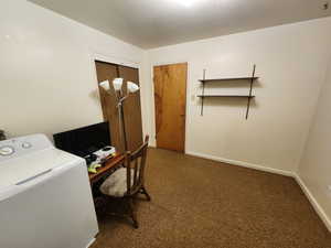 Office area with washer / dryer and dark carpet