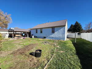 Back of house featuring a fenced backyard, a metal roof, a patio area, and a gazebo