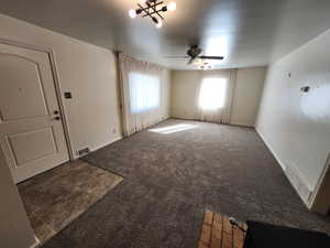 Unfurnished living room featuring carpet and ceiling fan