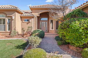 Entrance to property with stucco siding and a tile roof