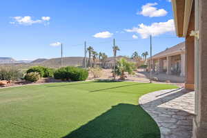 View of grassy yard featuring a patio area