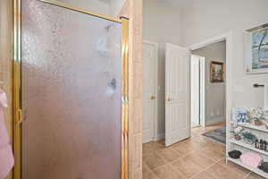 Bathroom featuring light tile patterned floors, a stall shower, and vanity