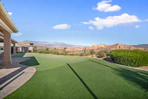 View of yard featuring a mountain view, a putting green, and a patio