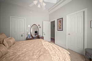 Bedroom with light colored carpet and a ceiling fan