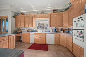 Kitchen featuring backsplash, white appliances, recessed lighting, light tile patterned floors, and light brown cabinetry