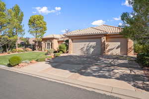 Mediterranean / spanish home with a tiled roof, a front lawn, driveway, stucco siding, and a garage