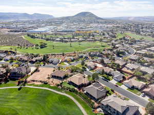 Aerial view of property's location with mountains, a local golf course, and nearby suburban area