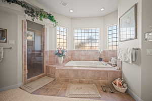 Bathroom with tile patterned floors, a bath, and a shower stall