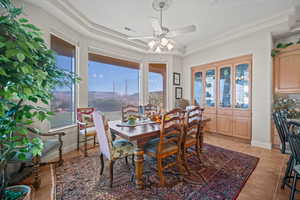 Dining space featuring a raised ceiling, light tile patterned flooring, and a ceiling fan
