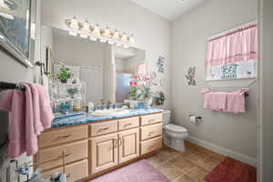Bathroom with vanity, a shower stall, and light tile patterned floors