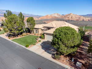 View of front facade with a mountain view, driveway, an attached garage, and a front yard