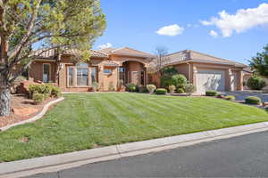 Mediterranean / spanish house with stucco siding, a front lawn, an attached garage, and a tile roof