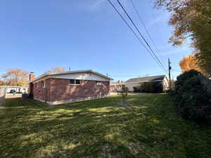 View of property exterior featuring brick siding and a chimney