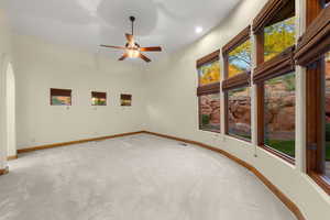 Unfurnished room featuring arched walkways, carpet floors, a ceiling fan, and recessed lighting